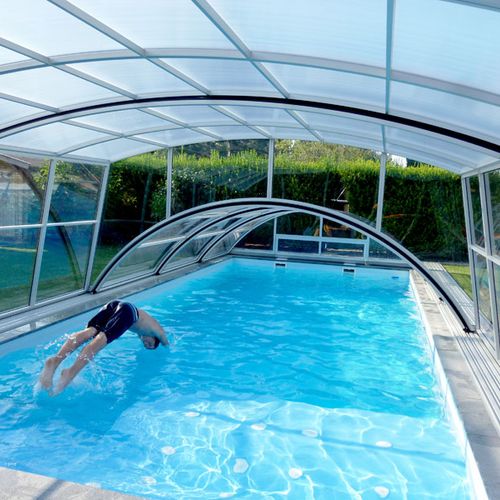 individuelle Schwimmbadüberdachungen über Pool in den ein Mann springt